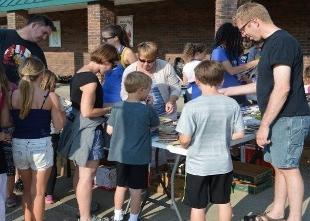 People gather around the table at an outdoor activity held by the Education Alumni Affinity Group